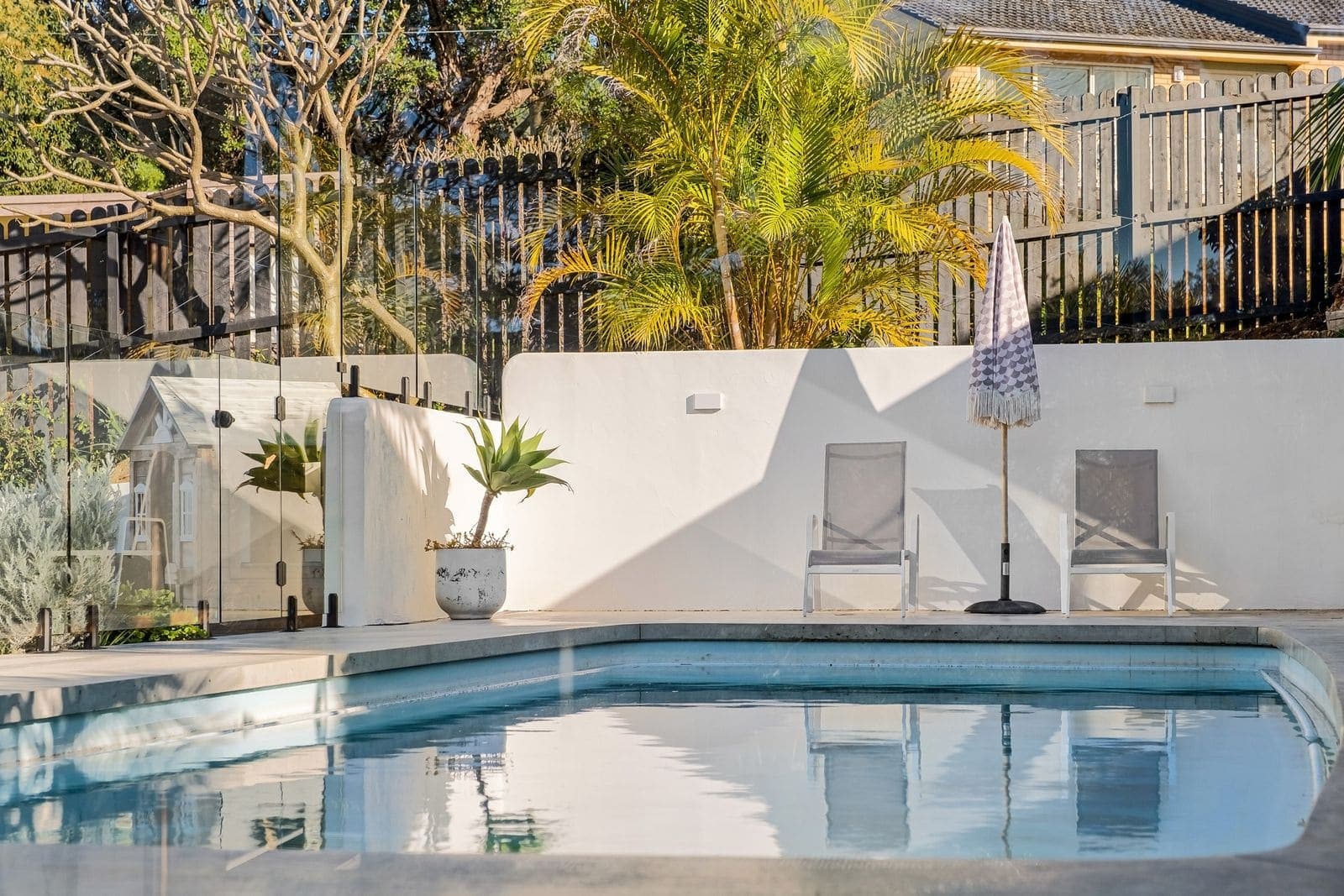 Rectangular pool with a smooth gelcoat finish in a walled garden